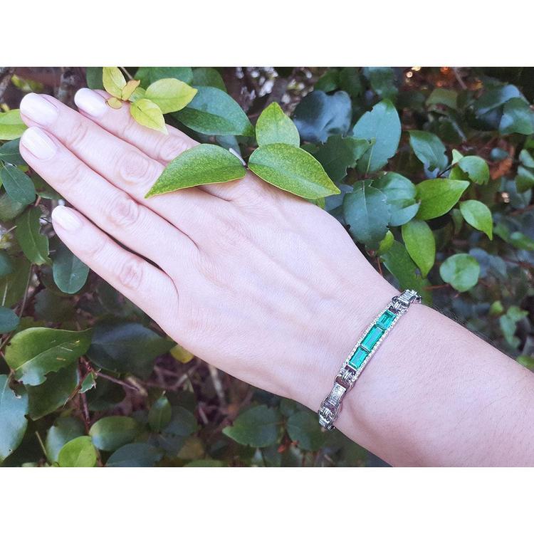 14k white gold bracelet with vibrant Colombian emeralds and princess-cut diamonds on a woman's wrist.