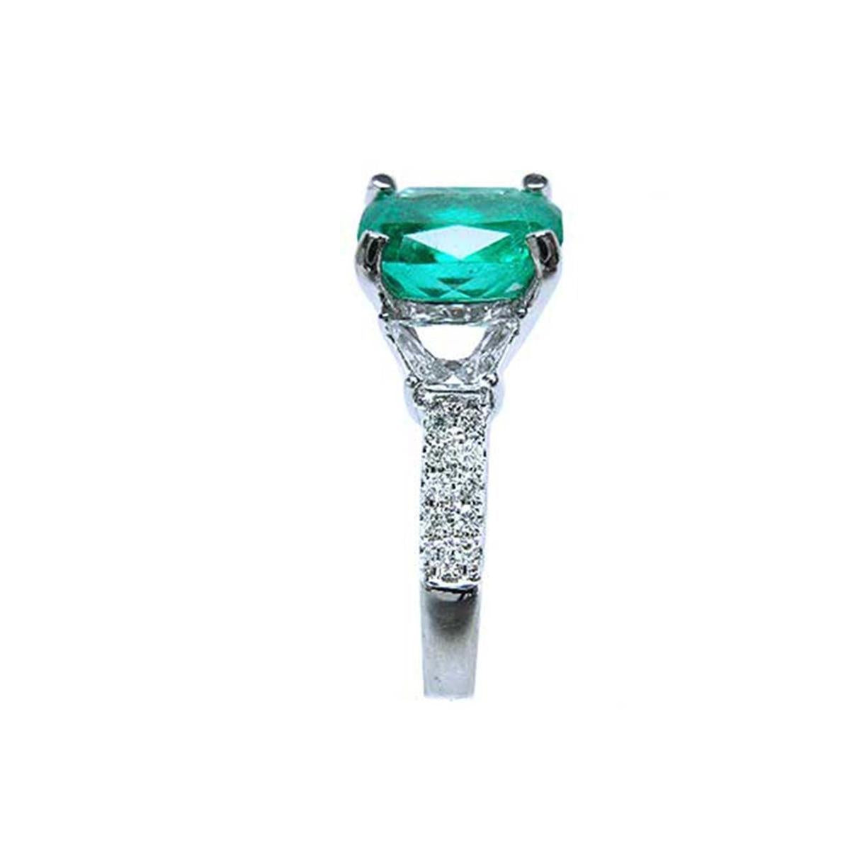 A bridal's cushion cut emerald and trapezoid side diamond ring in 18k white gold, side profile visible.