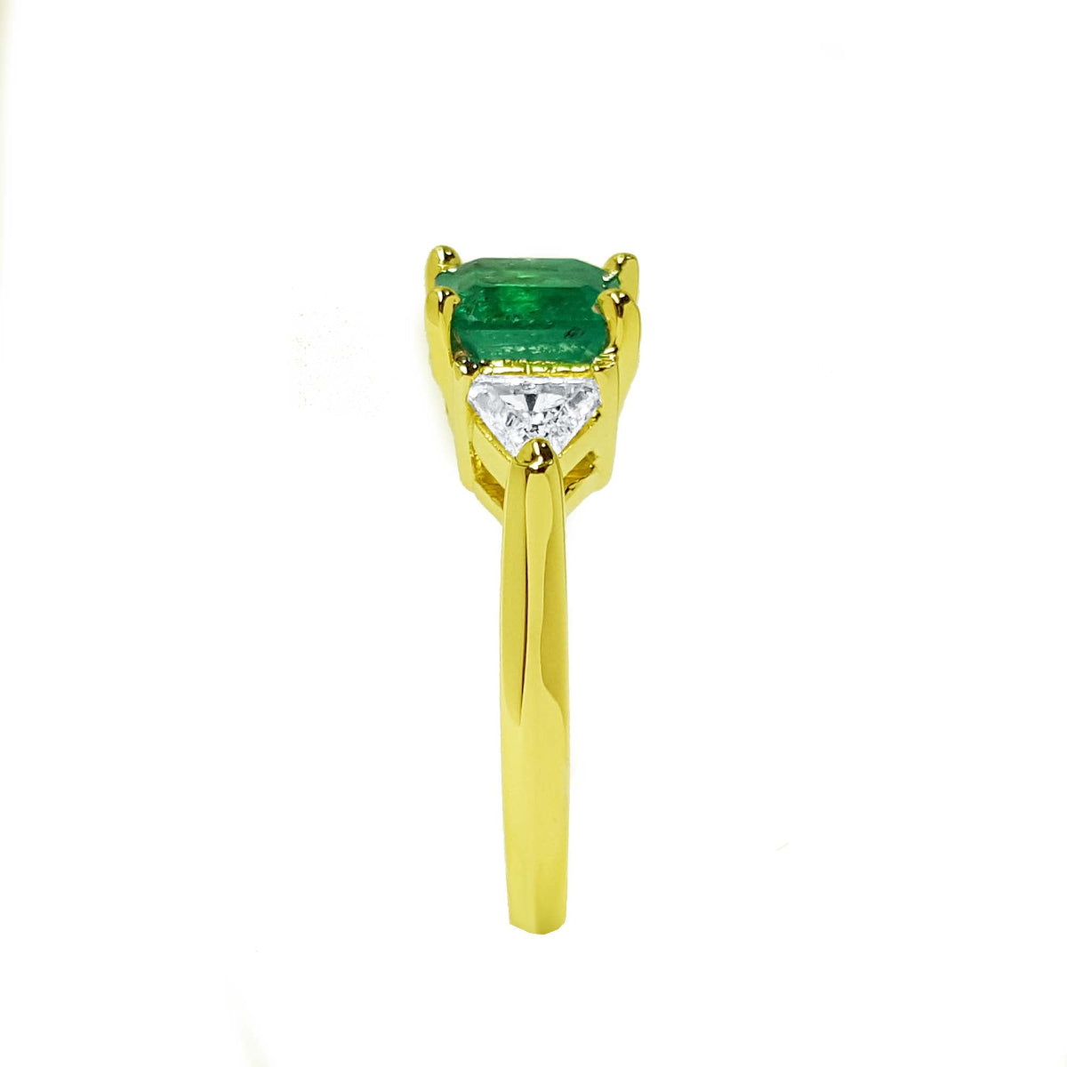 Women's Yellow gold 18k ring with a natural colombian emerald and trillion side diamonds.