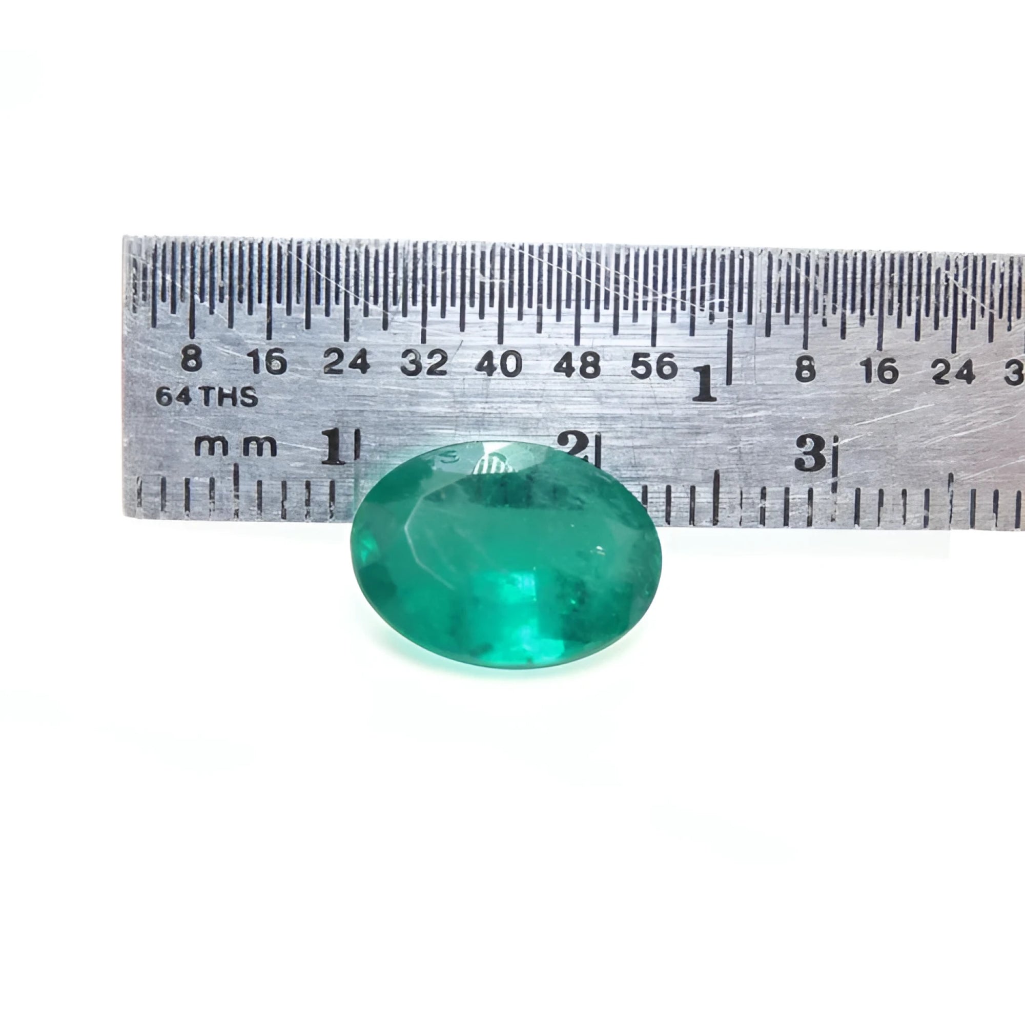 3.68 ct GIA certified loose oval emerald, bright bluish-green, displayed with a ruler for scale.