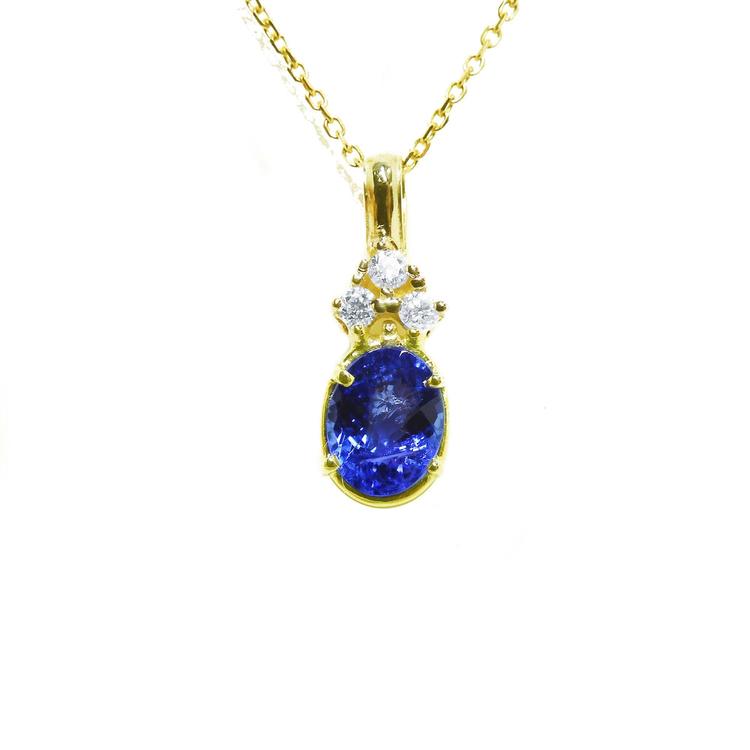 14K yellow gold pendant with an oval tanzanite and three round diamonds on a delicate chain.