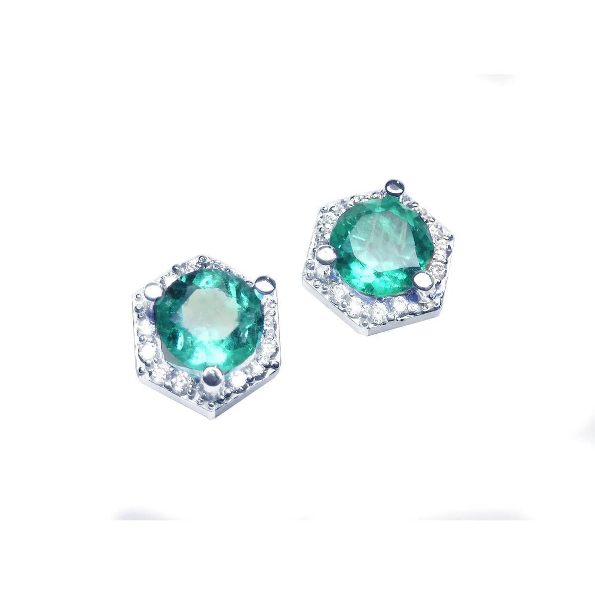 Diagonal top view position of pair of hexagonal halo diamond emerald stud earrings white gold.