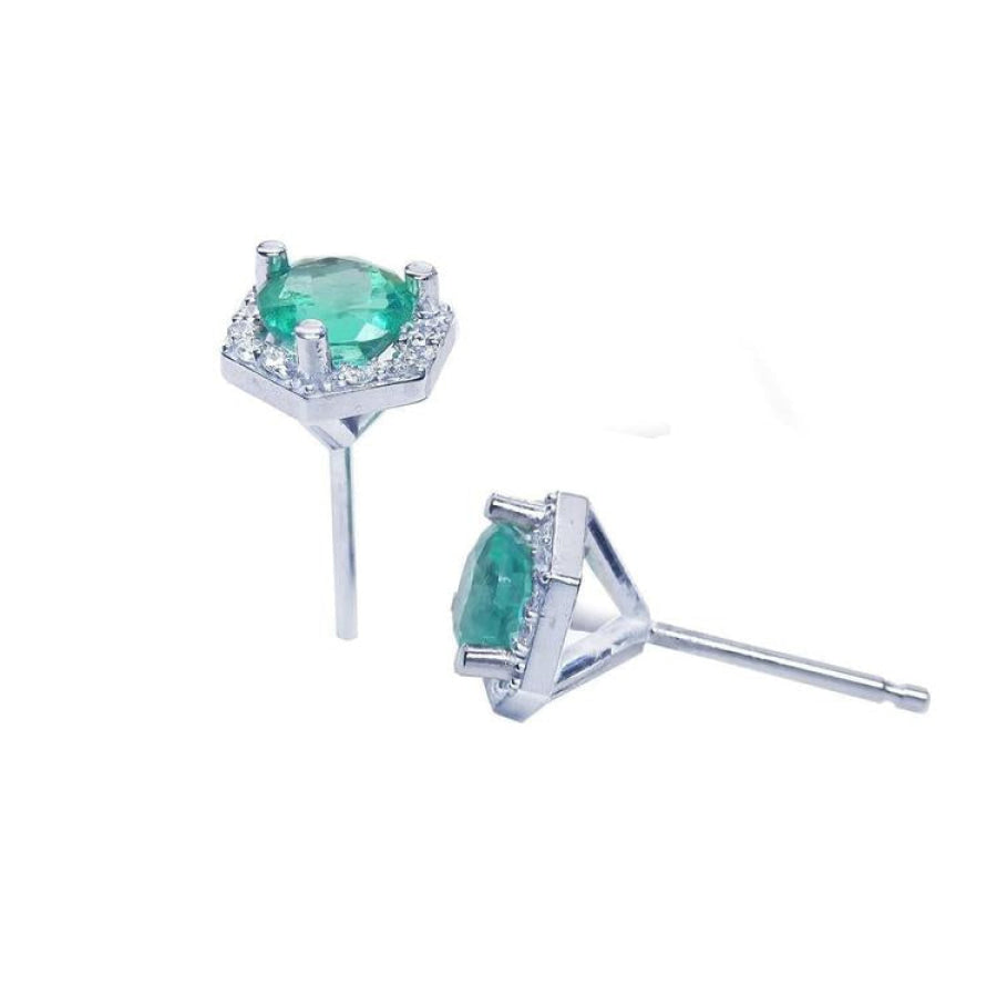 Round cut Colombian emerald stud earrings in 14K white gold with a hexagonal diamond halo.