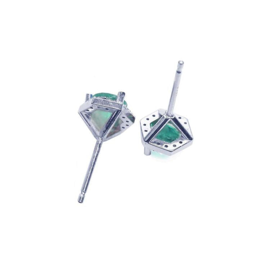 Pair of 0.74 ct round emerald stud earrings in 14K white gold with hexagonal diamond halo.