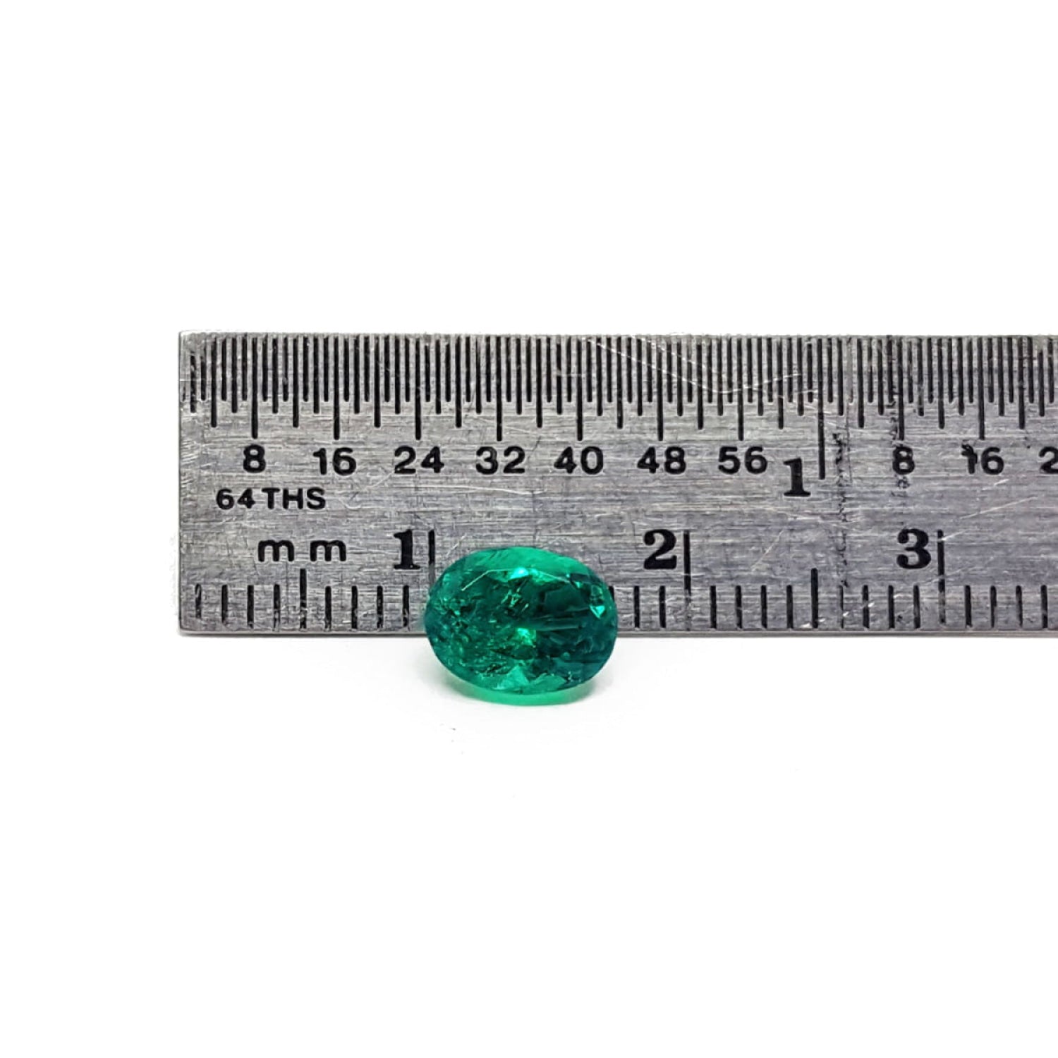 GIA Certified F1 0.98 ct. Oval Muzo Colombian Emerald loose emerald next to a ruler for measure.