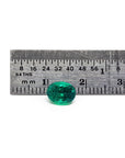 GIA Certified F1 0.98 ct. Oval Muzo Colombian Emerald loose emerald next to a ruler for measure.