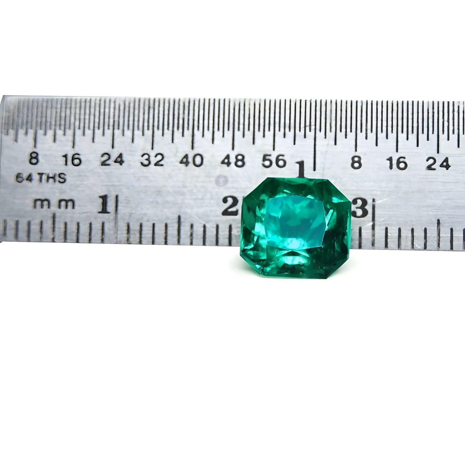 2.45 ct GIA certified Asscher cut emerald, vibrant bluish-green, next to a ruler for scale.