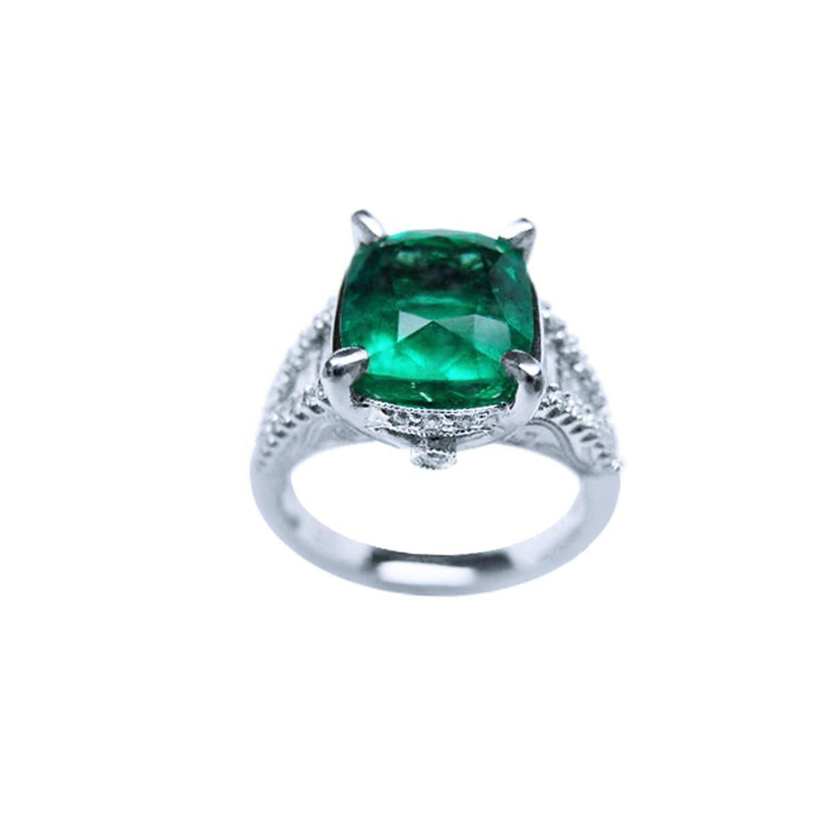 A gia certified cushion cut emerald ring for women in 18k white gold, top profile and sides visibles.
