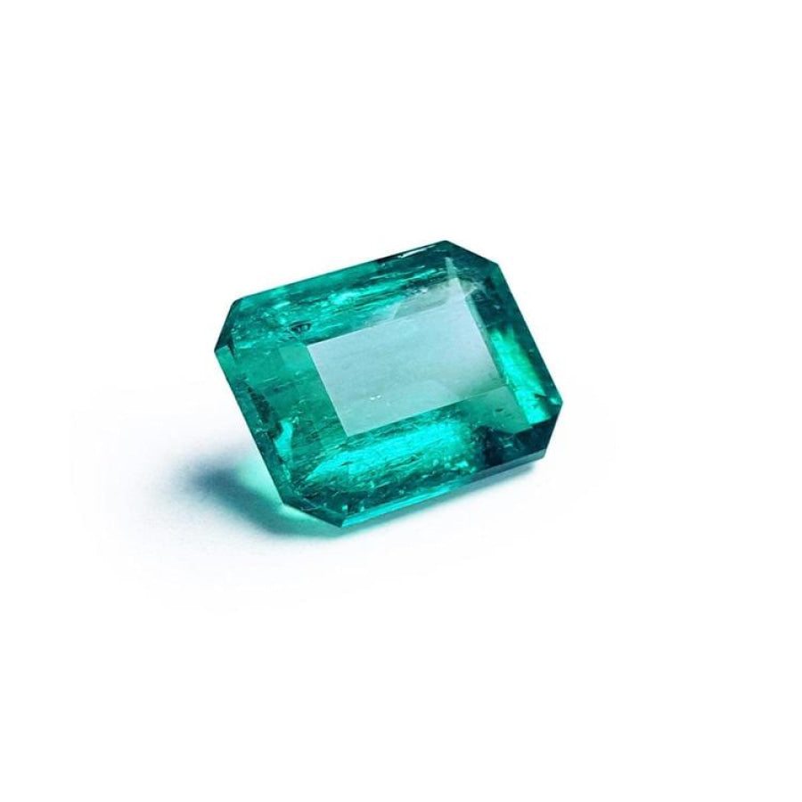 Vibrant bluish-green emerald-cut loose emerald from Muzo Colombia, 4.18 carats, on a white background.