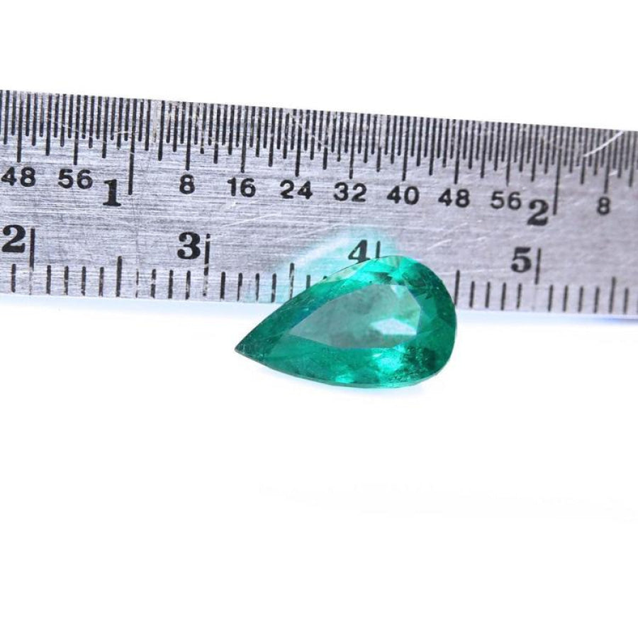 2.77 carat GIA certified pear cut Colombian emerald with vivid deep bluish-green hue, next to a ruler.
