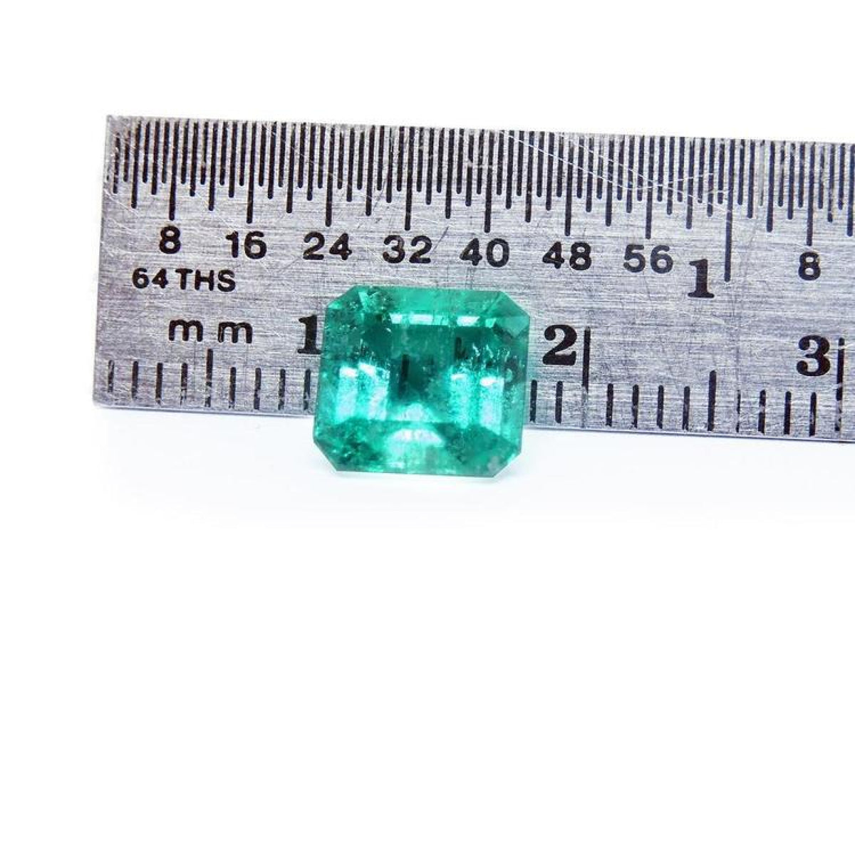 GIA certified 1.88 ct vibrant bluish-green Colombian emerald, shown next to a ruler for scale.