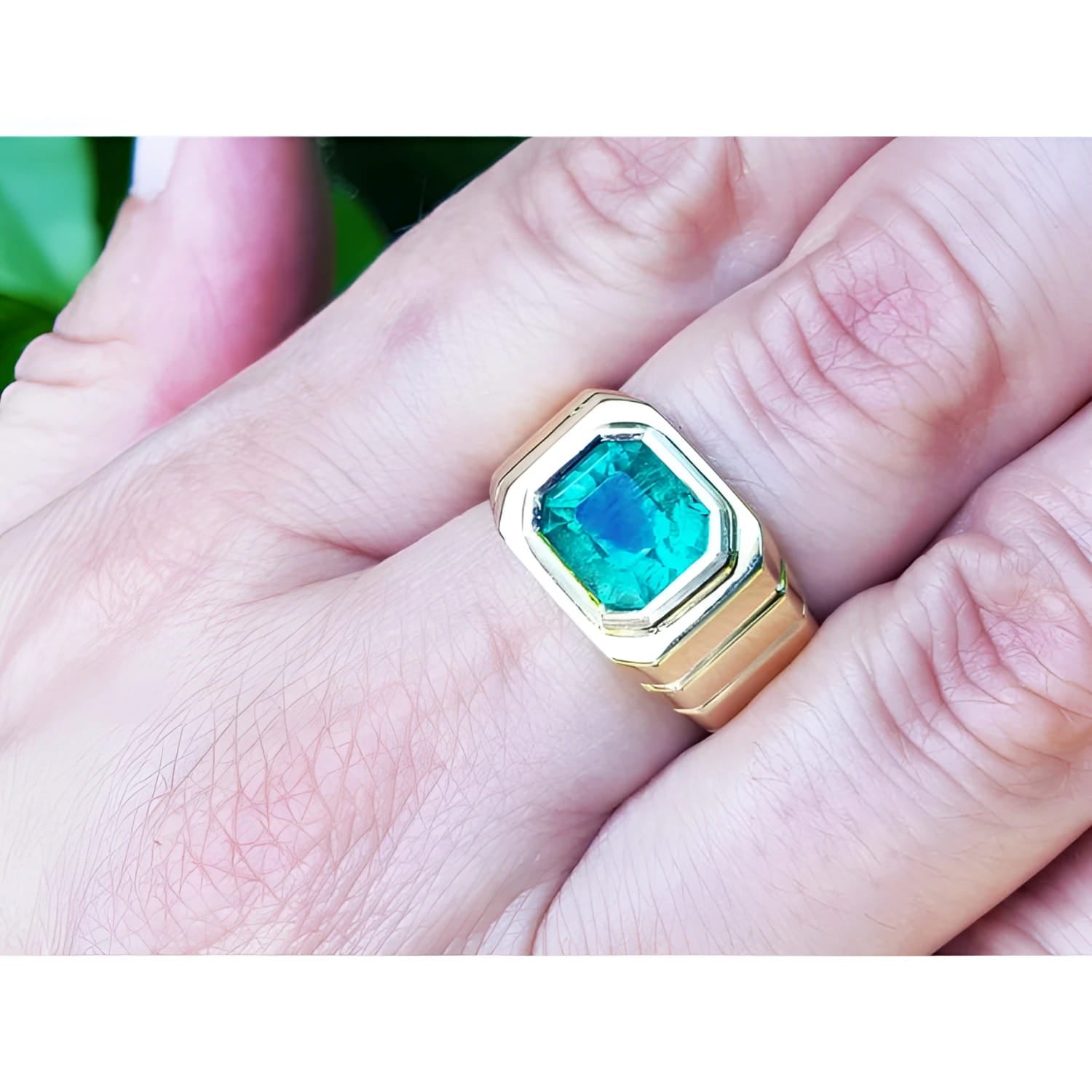 Men's 18K yellow gold ring with a rectangular, medium-deep green emerald in a full bezel setting.