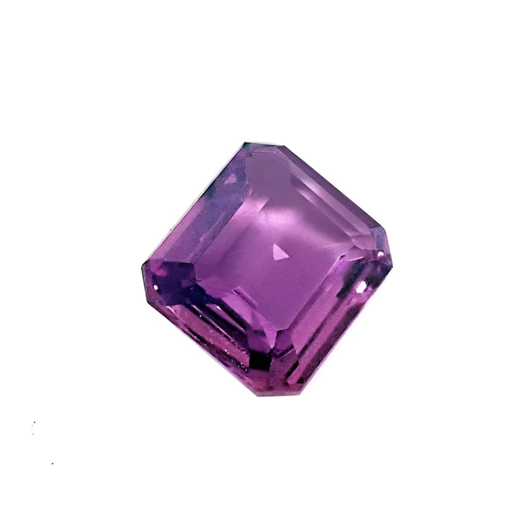 4.05 ct natural loose pink sapphire with an emerald cut, displaying vibrant purple hues.
