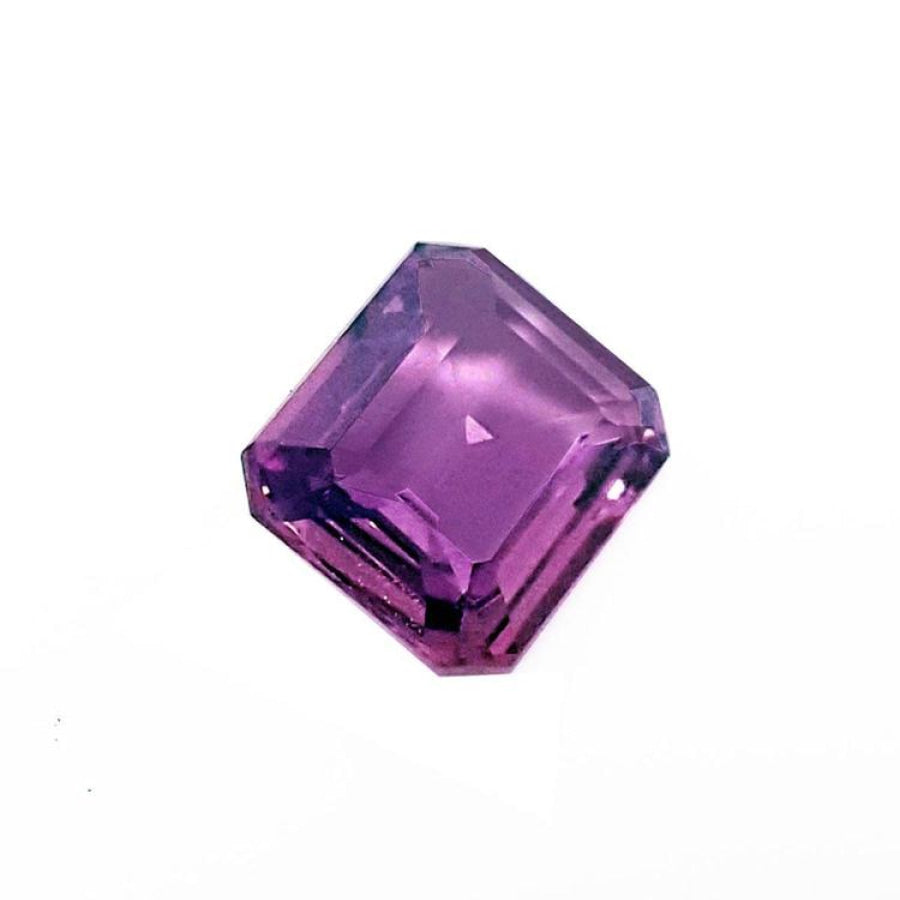 4.05 ct natural loose pink sapphire with an emerald cut, displaying vibrant purple hues.