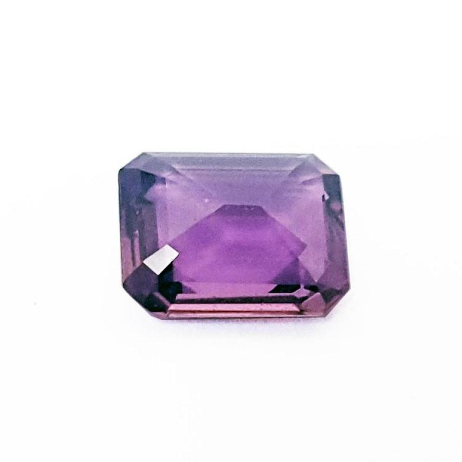 4.05 ct natural loose pink sapphire with an emerald cut, displaying a clear purple hue.