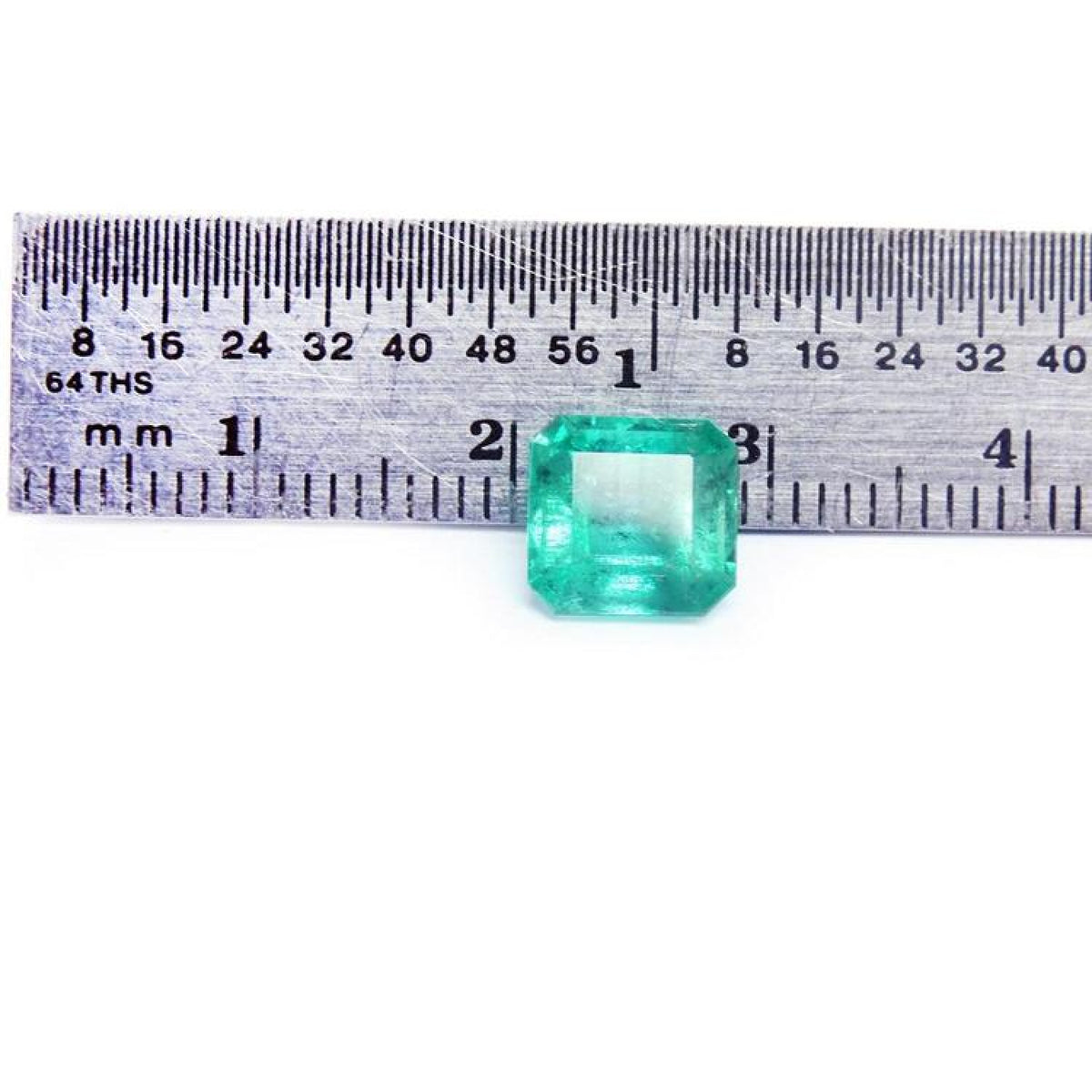 GIA certified 2.23 carat square octagonal Muzo Colombian emerald with vivid bluish-green hue, shown next to a ruler.