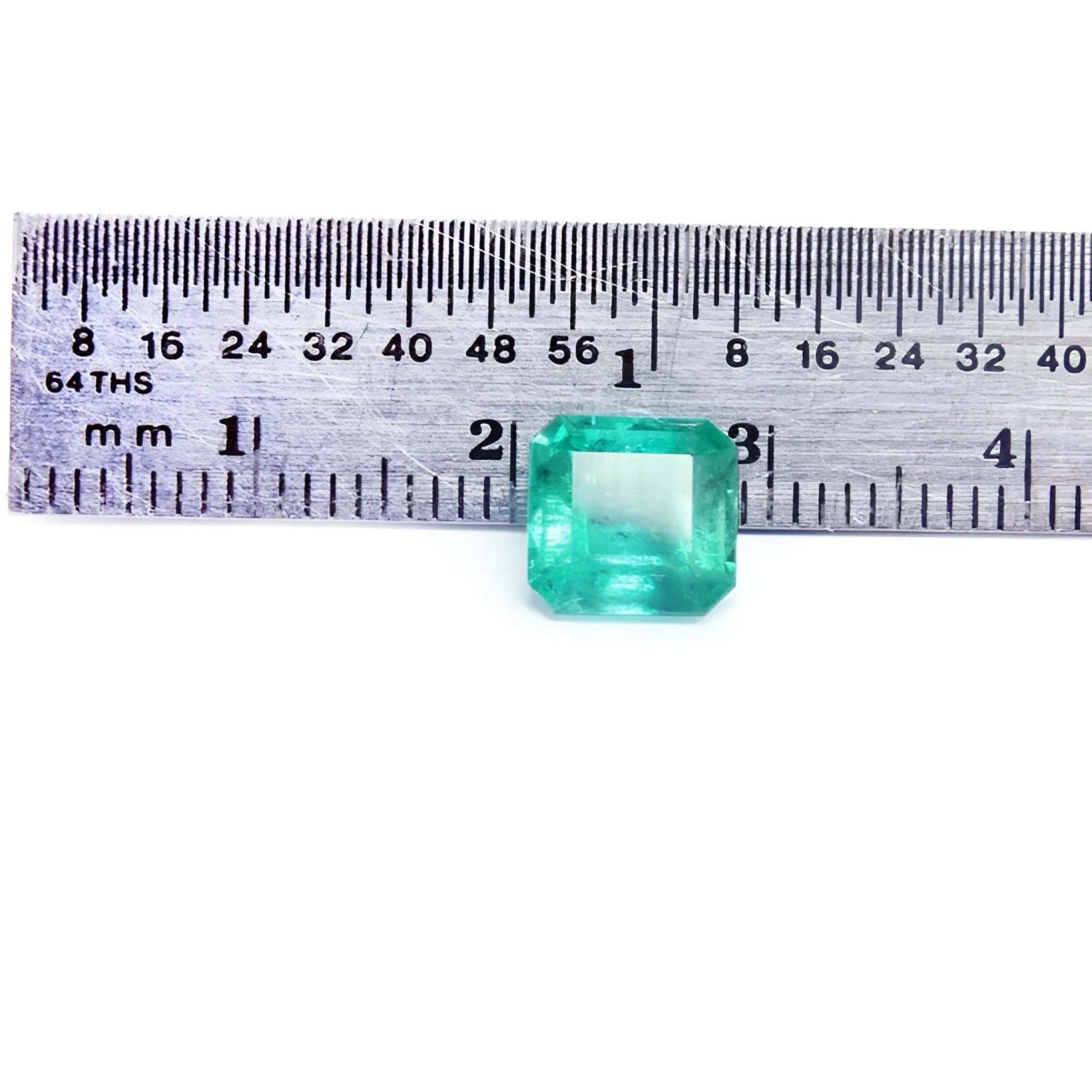 GIA certified 2.23 carat square octagonal Muzo Colombian emerald with vivid bluish-green hue, shown next to a ruler.