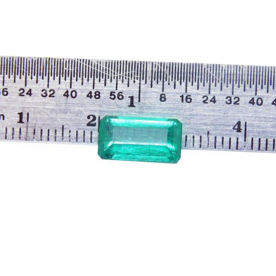 2.47 carat GIA certified loose Colombian emerald, sparkling bluish-green, rectangular cut, displayed against a ruler.