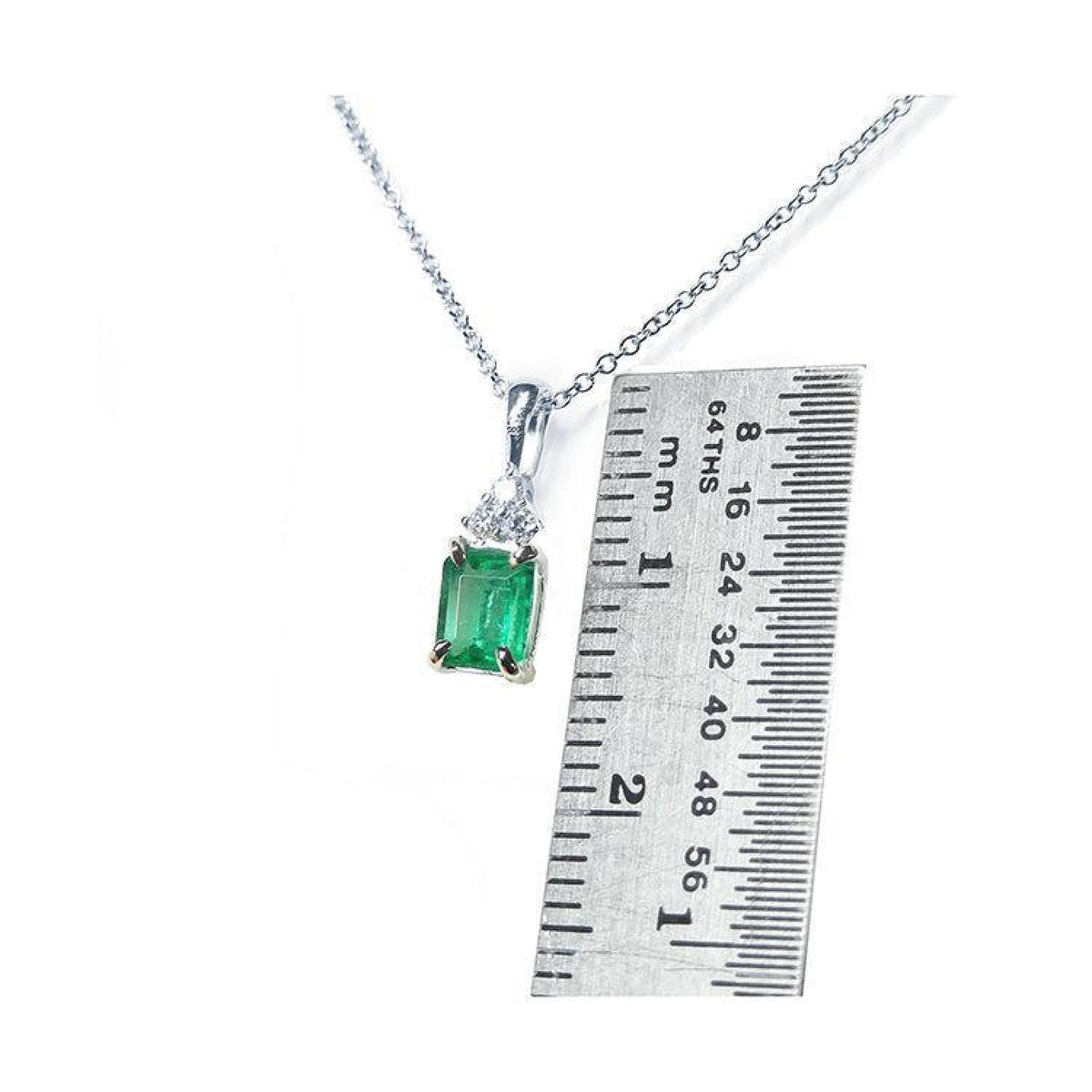 0.27 ct emerald necklace pendant in 14K white gold, shown next to a ruler for size.