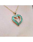 14K gold heart pendant necklace with brilliant round Muzo Colombian emeralds.