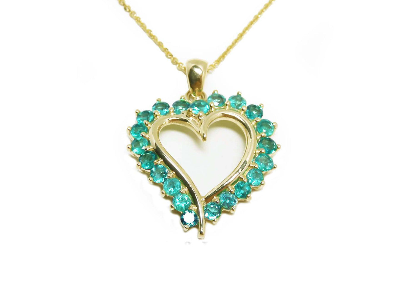 Heart-shaped pendant with emerald stones on a gold chain topside view.