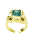 Gold ring for men with a natural emerald on a white background