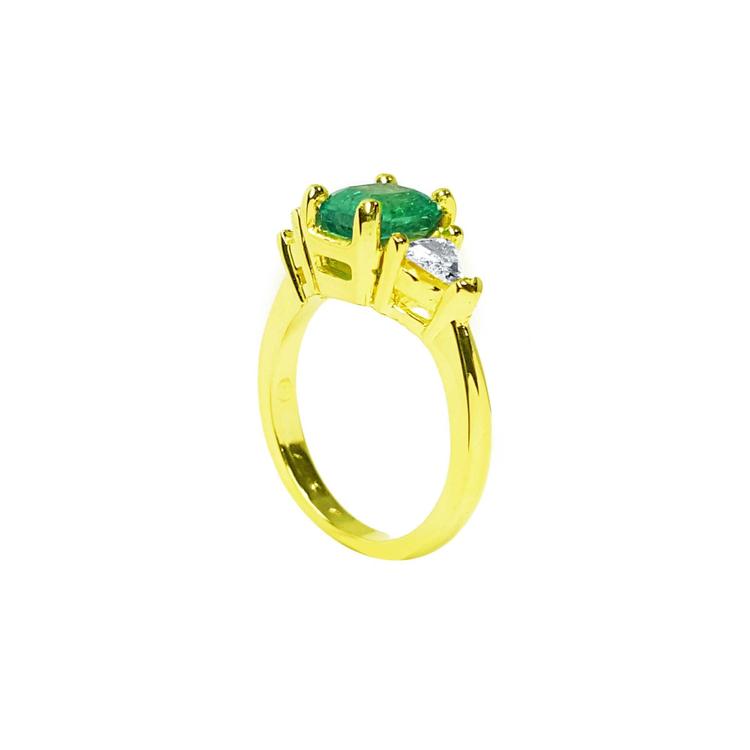 18k gold ring with a 1.51 ct. oval emerald and two trillion-cut side diamonds.