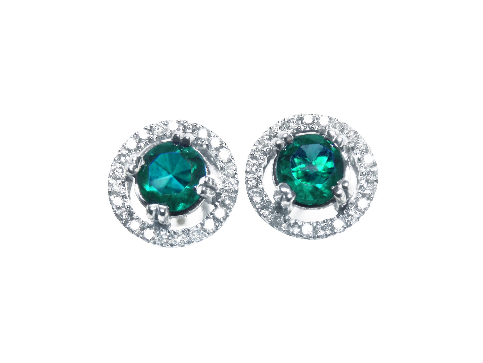Pair of halo diamond stud earrings with natural Muzo Colombia emeralds, on a top view.