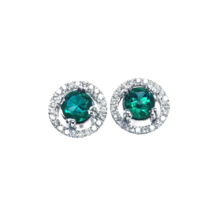 Pair of halo diamond stud earrings with natural Muzo Colombia emeralds, on a top view.