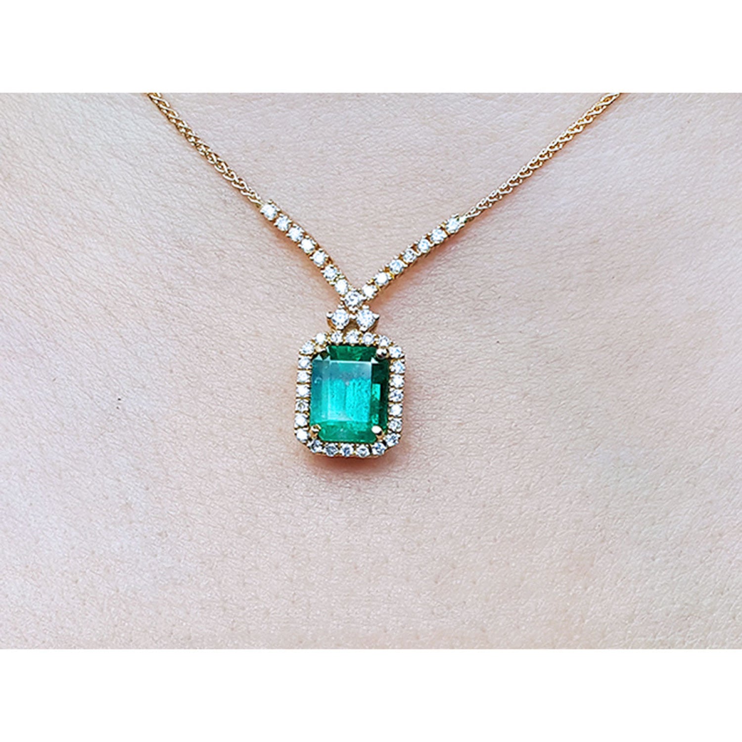 Emerald necklace with halo natural diamonds on a 14K yellow gold chain.