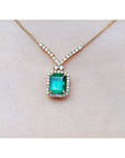 Emerald necklace with halo natural diamonds on a 14K yellow gold chain.