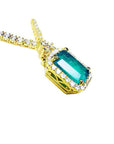 Emerald halo necklace with natural diamonds on a 14K yellow gold chain.