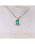 3.43 ct emerald halo necklace with natural diamonds on a 14K yellow gold chain.