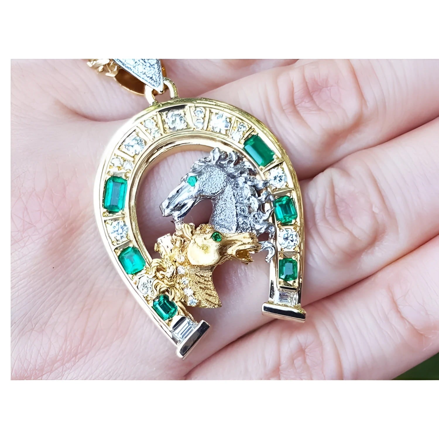 18K yellow gold horseshoe pendant with emeralds, diamonds, and two horse heads.