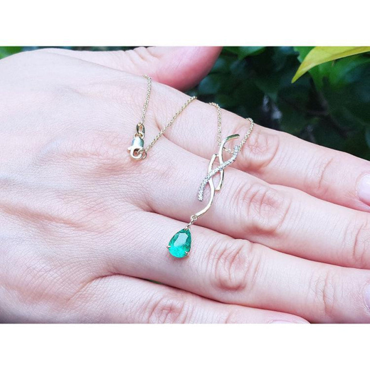 14K yellow gold twisted slider necklace with a medium deep green pear-shaped emerald pendant.