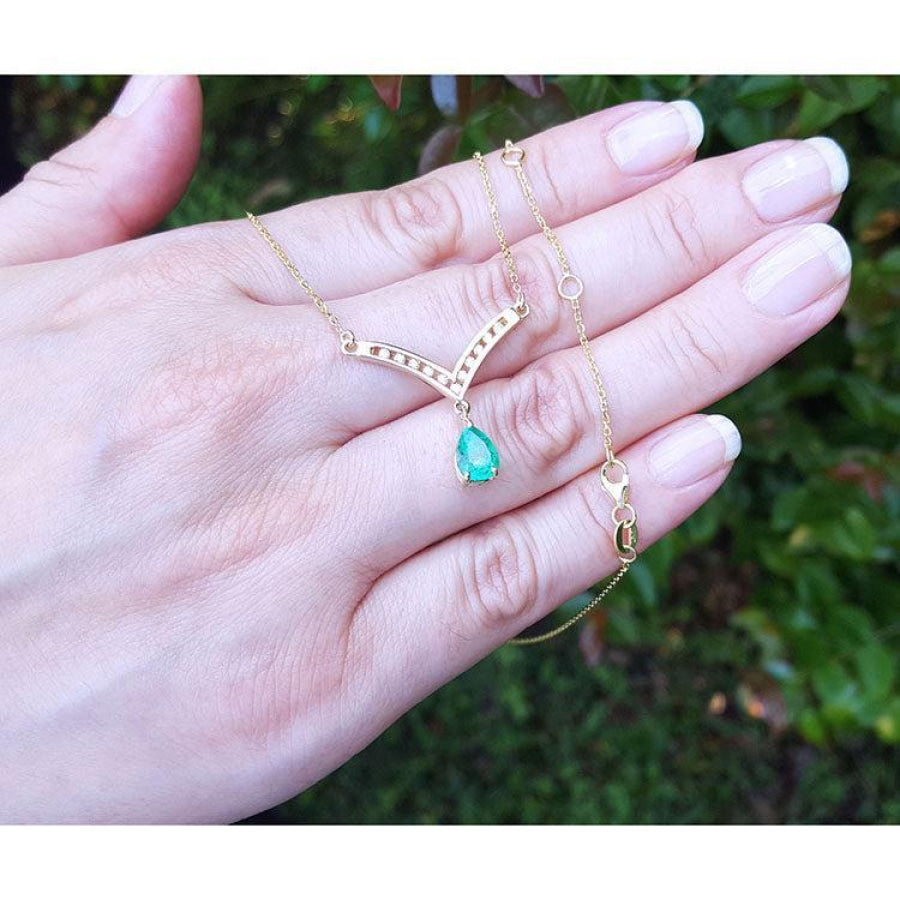 1.01 carat pear cut emerald necklace with accent diamonds set in a 14K yellow gold V-chevron design.