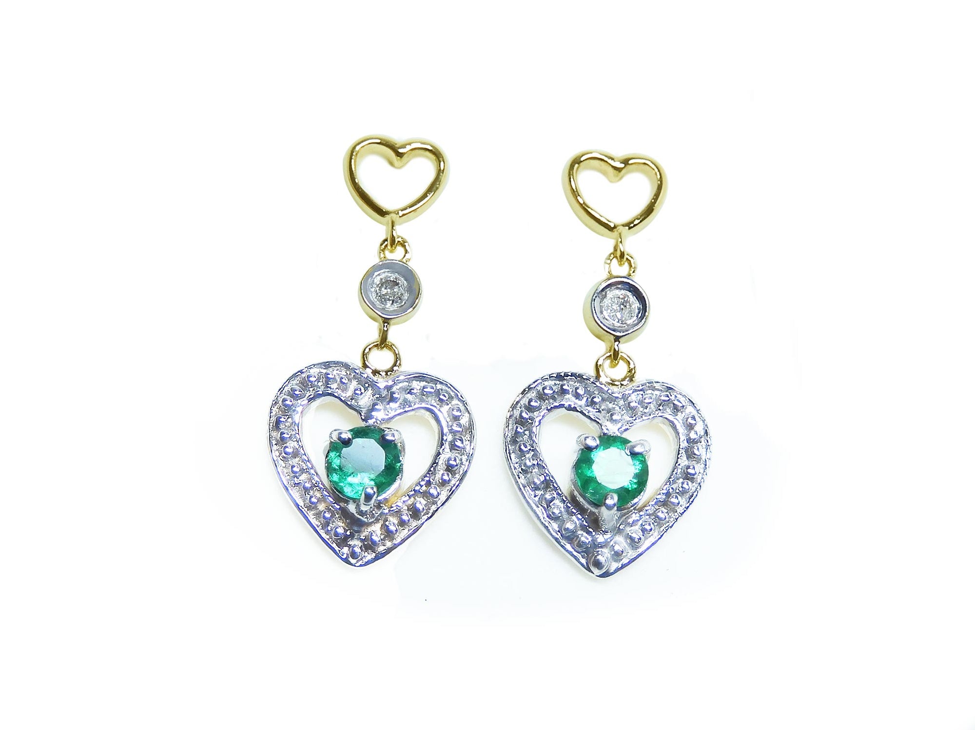 Front position of a pair of heat shaped earrings with round cut emeralds, top view.
