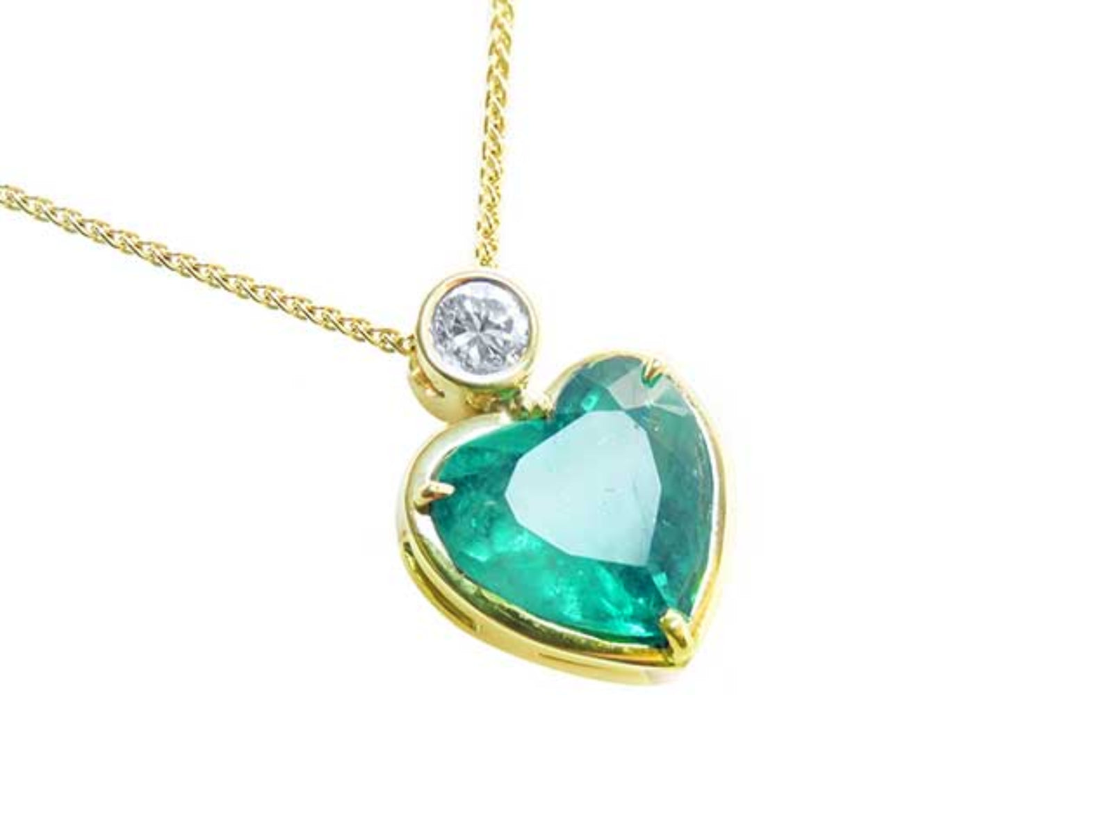 Emerald heart shaped pendant with a yellow gold necklace, right side position top plein view