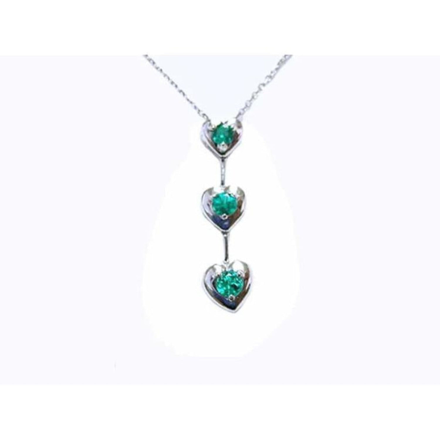 14K white gold journey pendant necklace with three heart-shaped settings, each holding a round emerald.