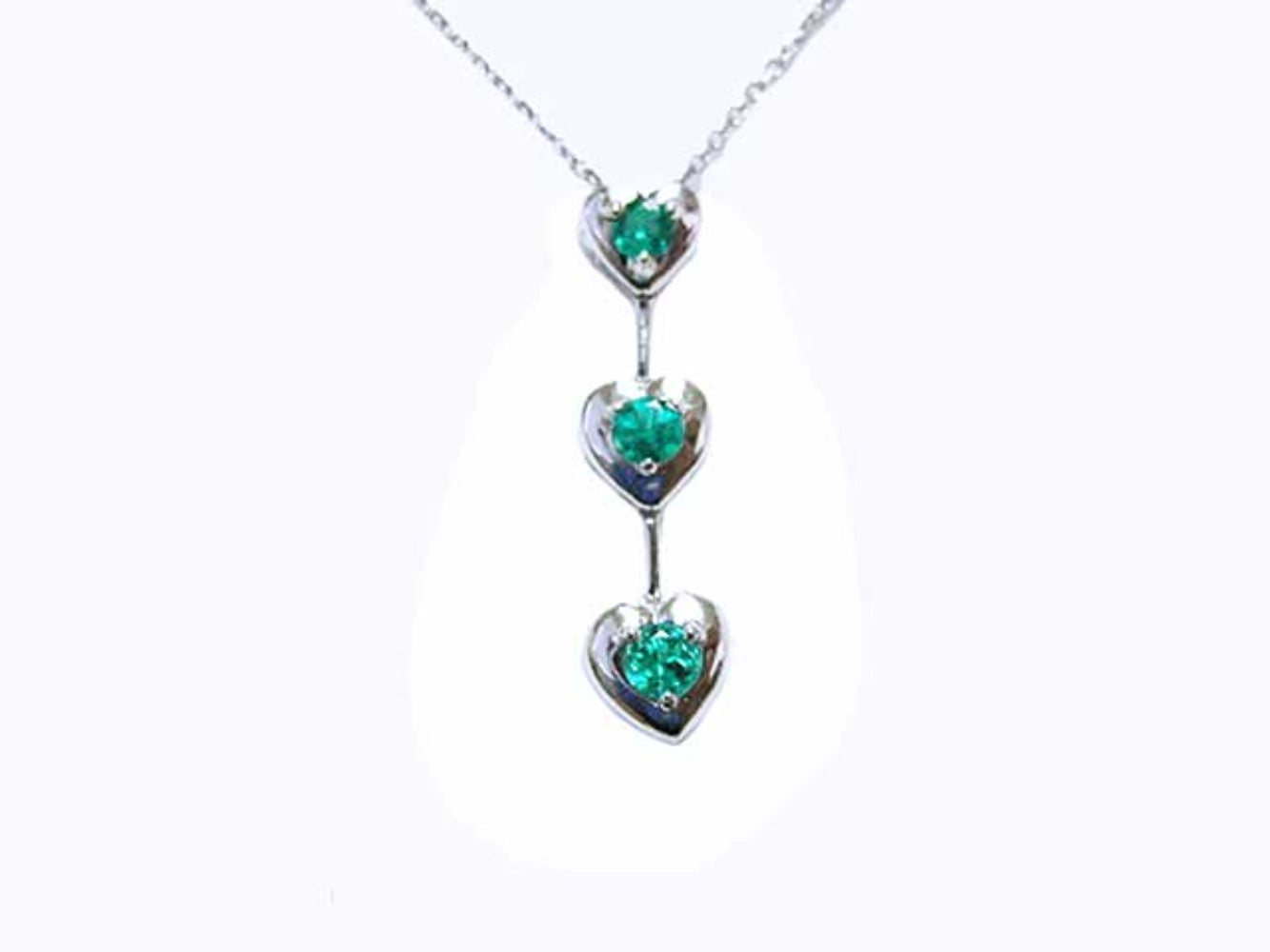 A three hearts emerald journey pendant necklace in 14j white gold.