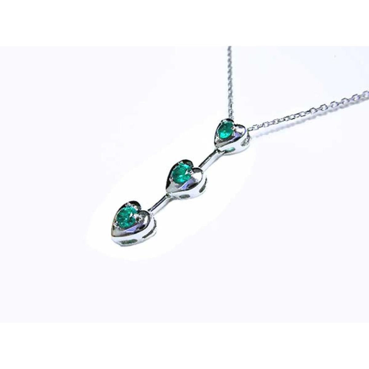 White gold necklace with natural emeralds heart-shaped stones on a white background