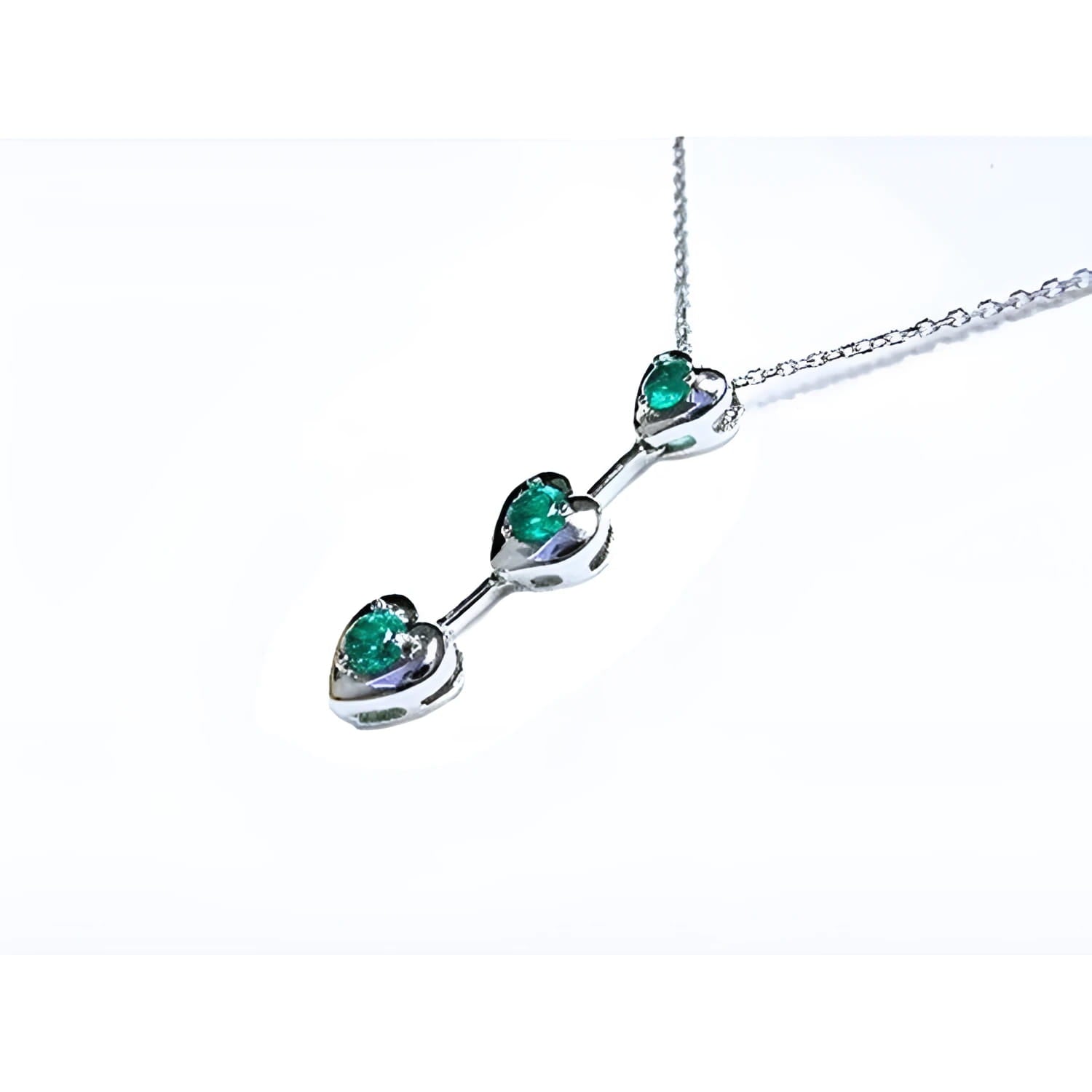 14K white gold heart journey pendant necklace with three round Colombian emeralds.