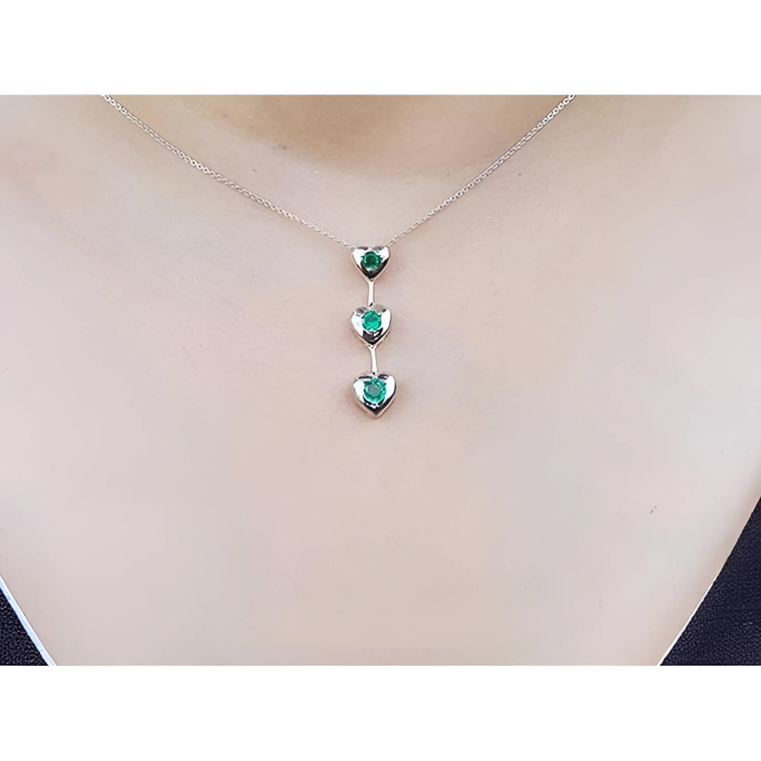 14K white gold heart emerald journey pendant necklace with three round-cut Colombian emeralds.