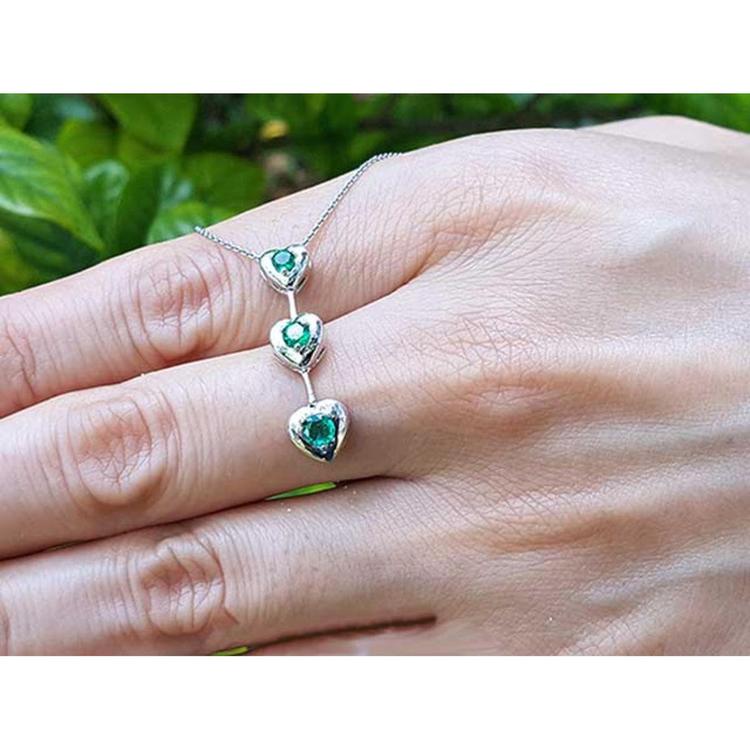 14K white gold heart journey pendant necklace with three round-cut Colombian emeralds.