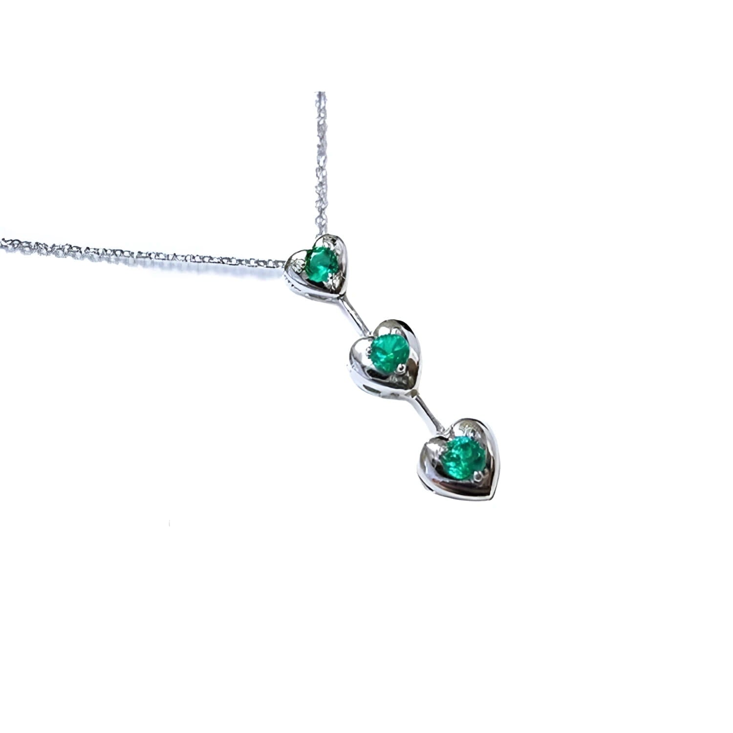 Three hearts emerald journey pendant necklace in 14k white gold topside view.
