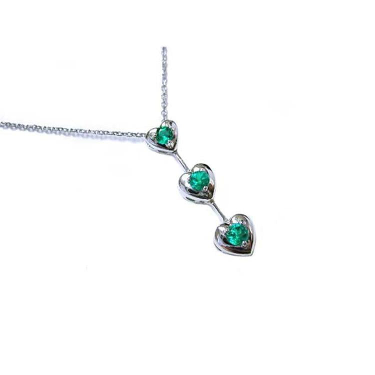 Three hearts emerald journey pendant necklace in 14k white gold topside view.