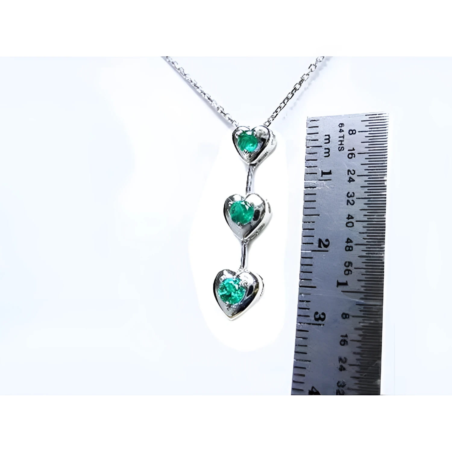 14K white gold heart journey pendant necklace with three round-cut Colombian emeralds.