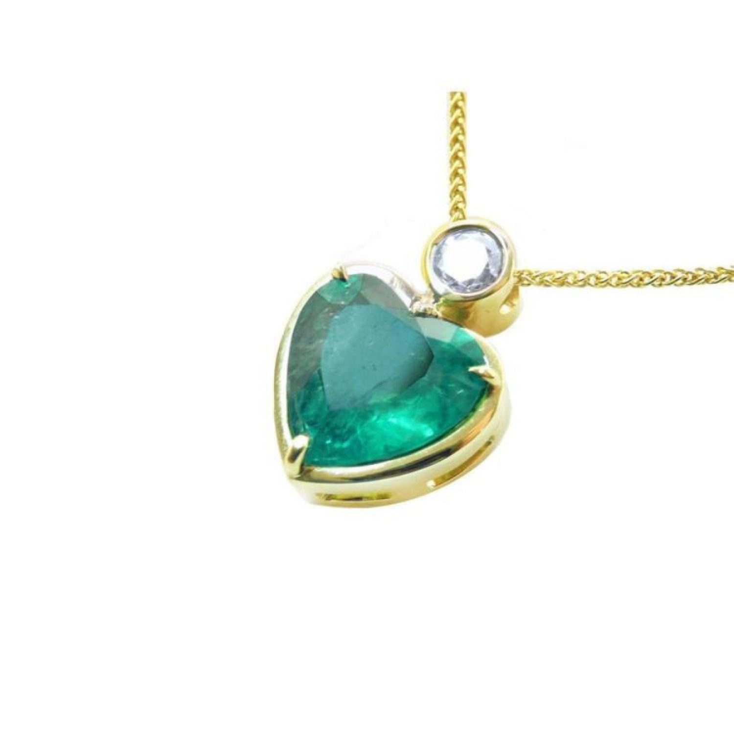 Heart-shaped emerald pendant in 18K yellow gold with a slider bail and bezel-set diamond.