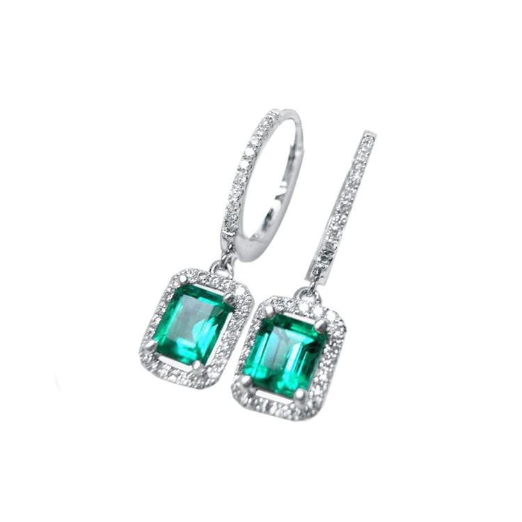 Pair of Colombian dangle emerald hoop earrings, plain top view on a left side position.