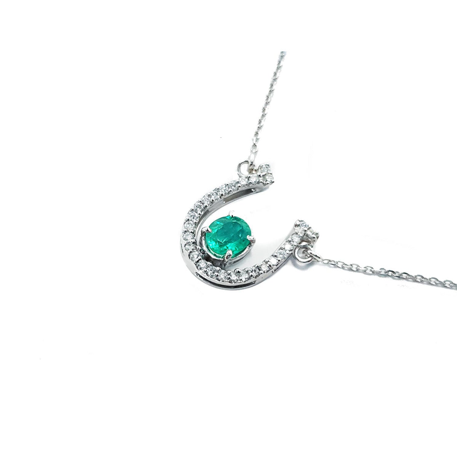 14K white gold horseshoe necklace with oval emerald and natural diamonds.